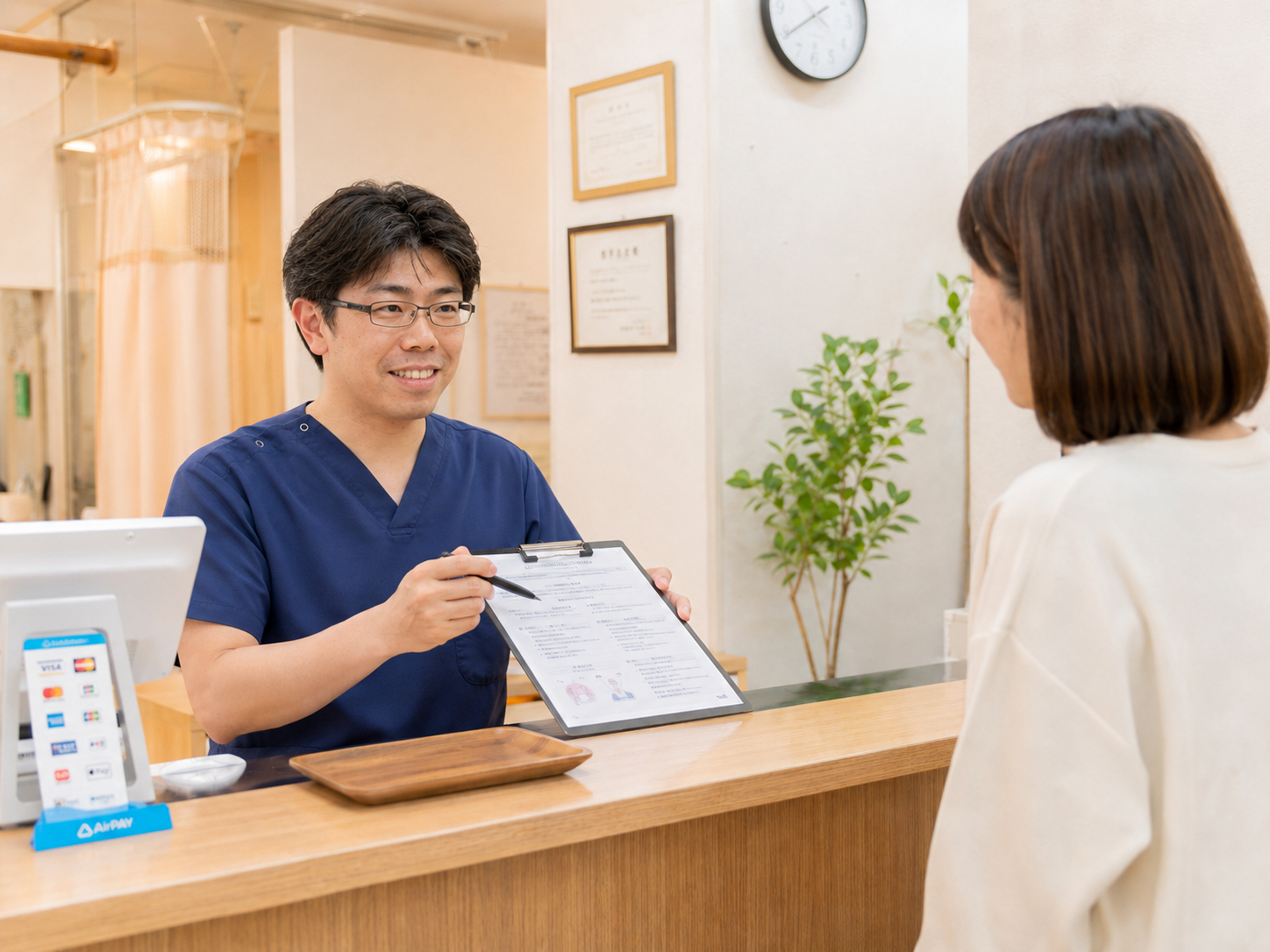 くめ鍼灸整骨院で久米院長が施術後の状態や今後の通院方針を患者さんへ説明する様子